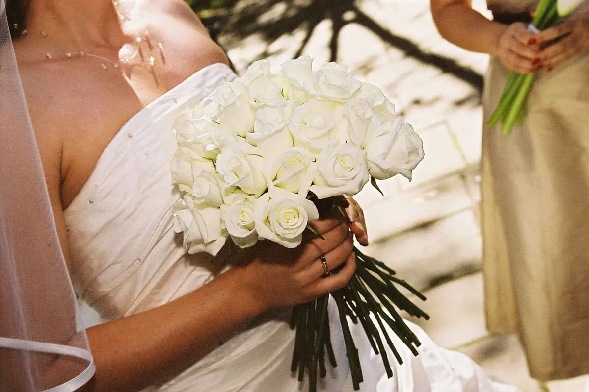 Bride holding white rose bouquet