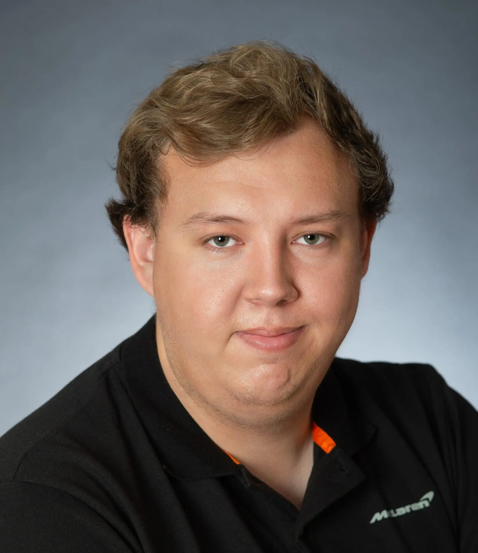 Person in black shirt with short curly hair.