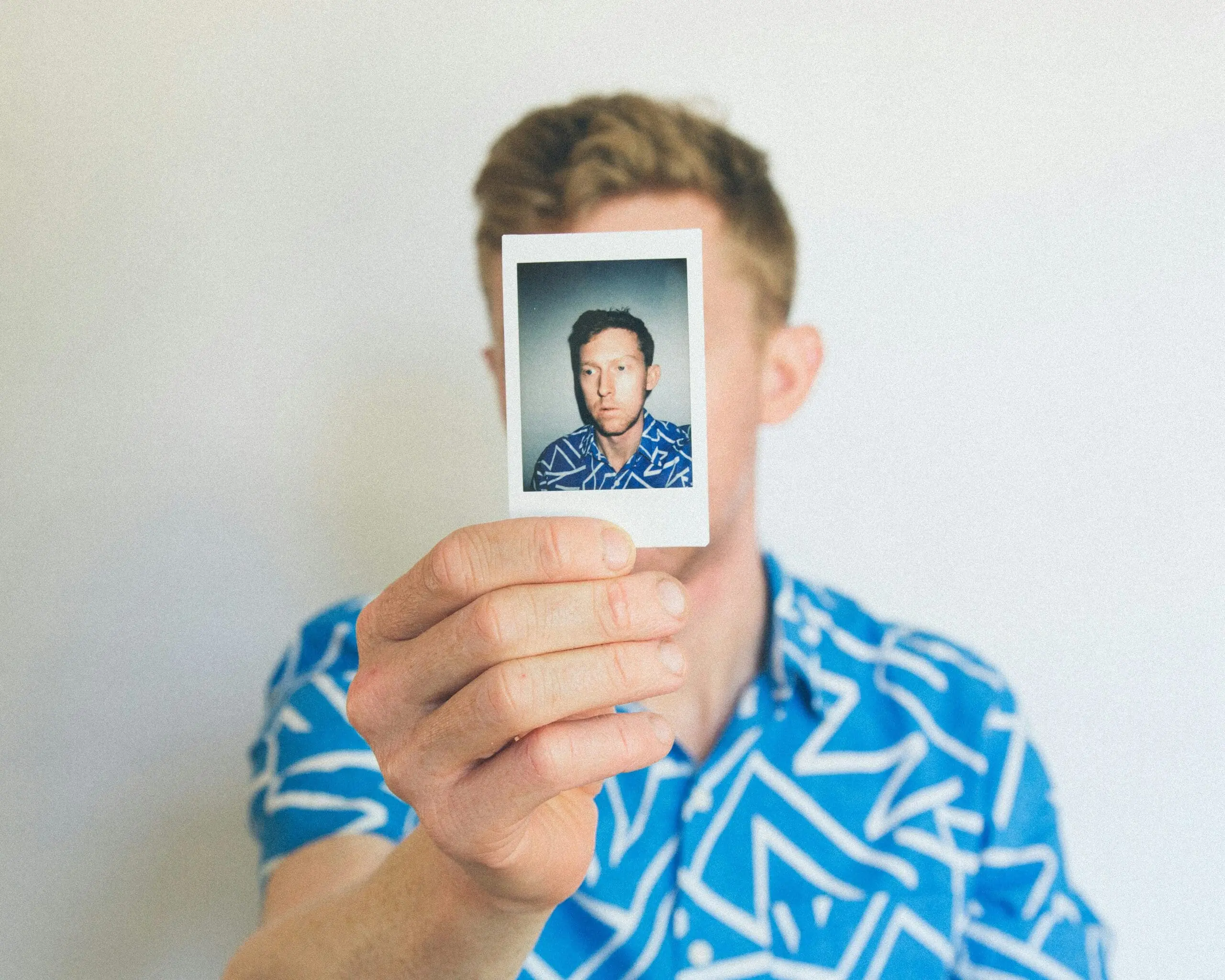 Person holding a Polaroid photo close-up.