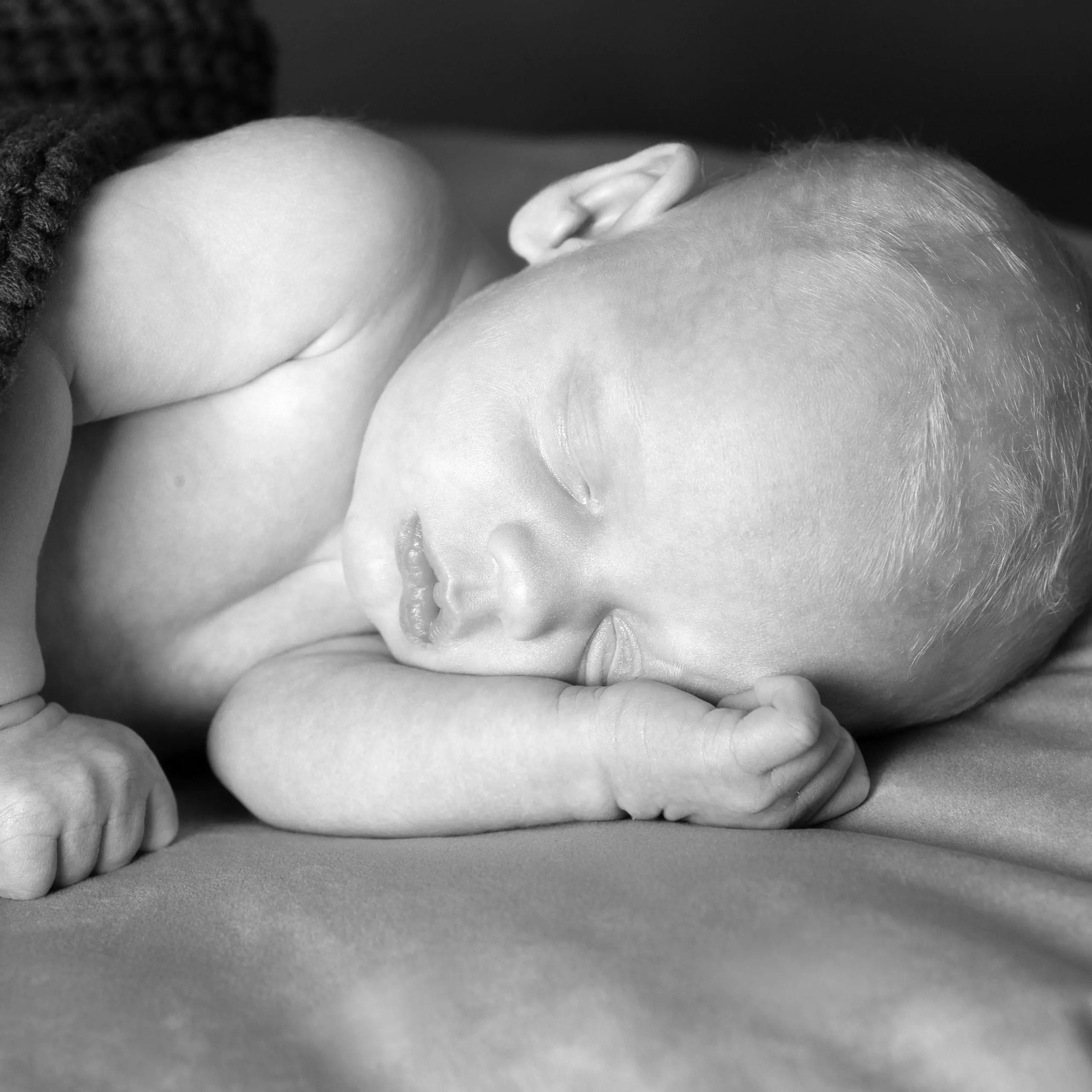 Newborn baby peacefully sleeping, black and white photo.
